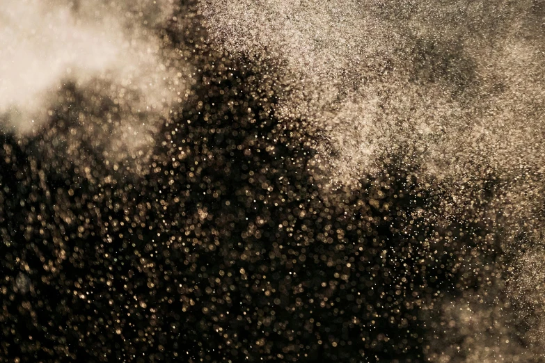 a man riding a snowboard down a snow covered slope, a microscopic photo, by Daniel Lieske, floating dust particles, glitter gif, gold and black metal, close up bokeh hiperrealistic