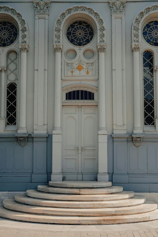 a red fire hydrant sitting in front of a building, a picture, inspired by Christopher Wren, pexels contest winner, neoclassicism, symmetrical doorway, alabaster gothic cathedral, white and blue color scheme, standing inside of a church