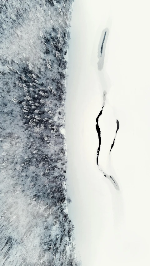 a man riding a snowboard down a snow covered slope, an album cover, by Christen Dalsgaard, pexels contest winner, land art, view from above, white lava, one contrasting small feature, frozen river