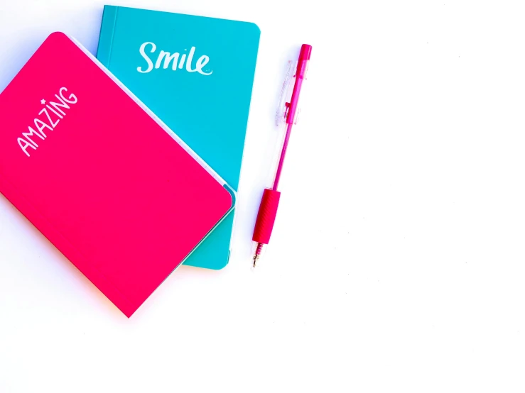 a couple of notebooks sitting next to each other, by Nicolette Macnamara, pexels, minimalism, in the colors hot pink and cyan, large smile, white background, background image