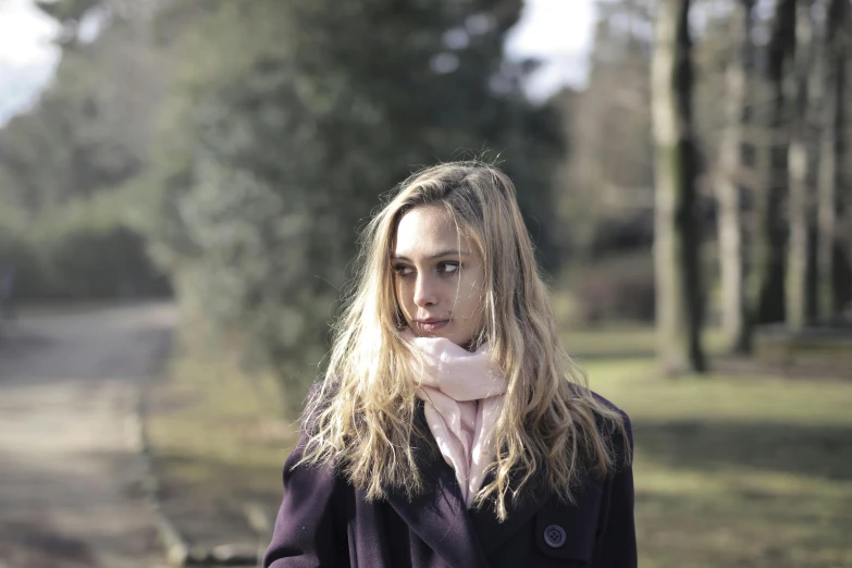 a woman wearing a purple coat and a pink scarf, a portrait, by Alice Mason, pexels, side portrait of a girl walking, looking melancholy, portrait n - 9, in a park