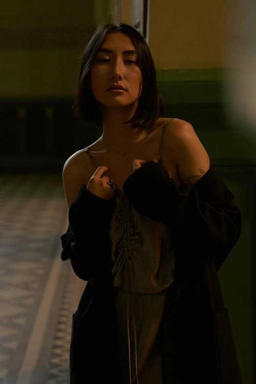 a woman standing in a hallway holding a cell phone, inspired by Jean-Jacques Henner, trending on pexels, hyperrealism, gemma chan beautiful girl, wearing a camisole, cinematic. by leng jun, movie promotional image