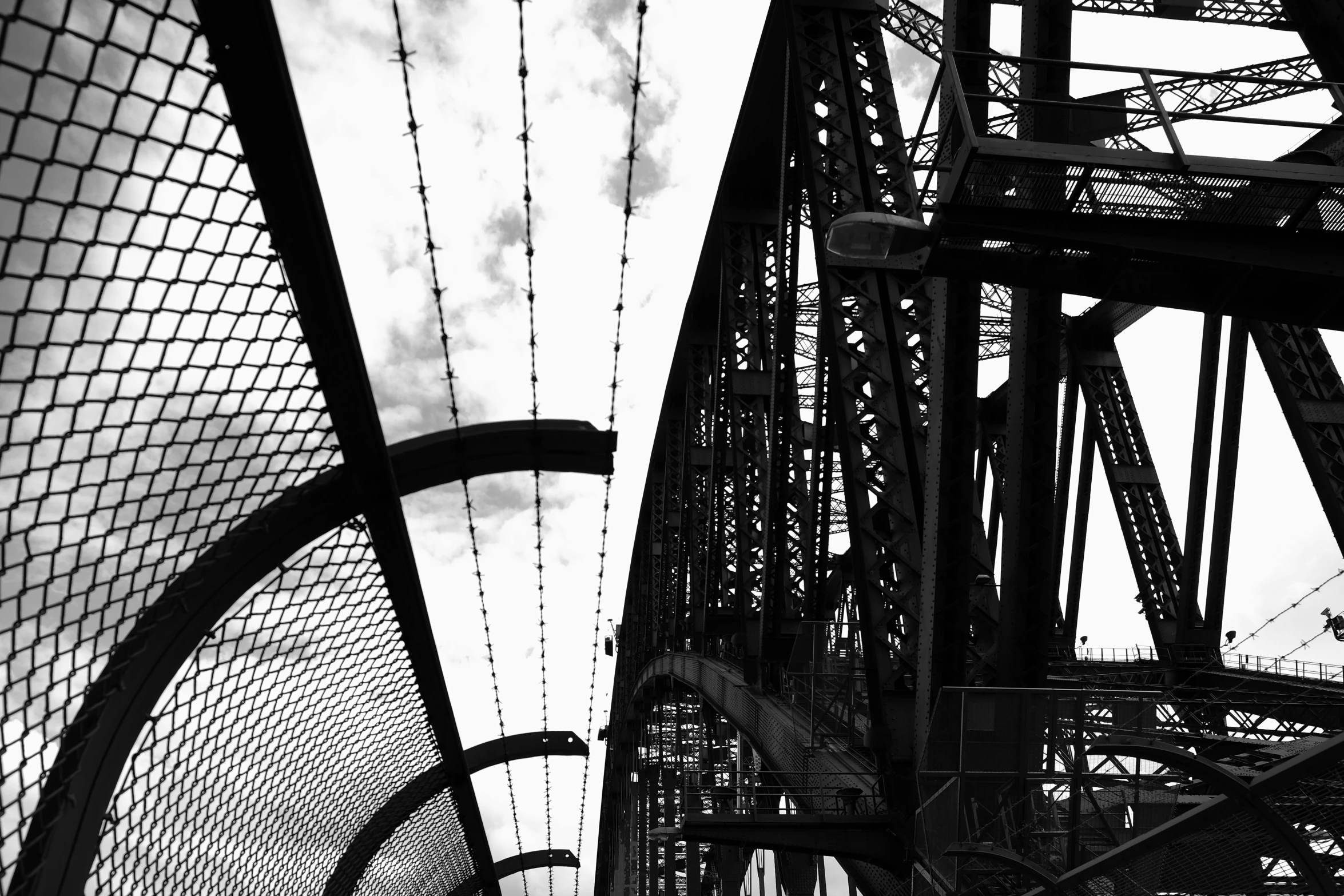 a black and white photo of a bridge, a black and white photo, inspired by Sydney Carline, rusty metal towers, terrified 👿, red trusses, paul davey