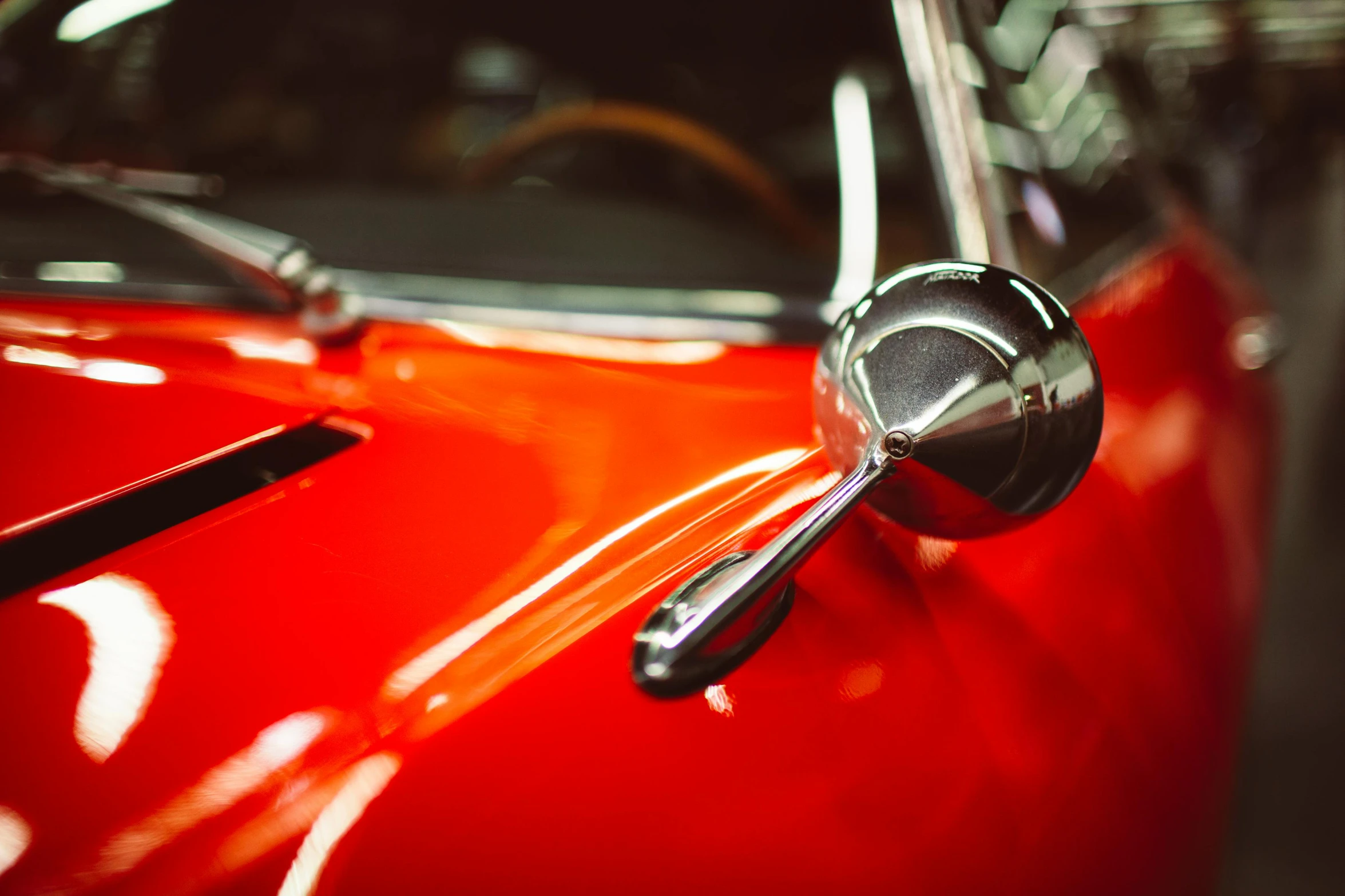a close up of the front end of a red car, pexels contest winner, photorealism, levers, 1960s color photograph, 4k photo”, vibrant orange
