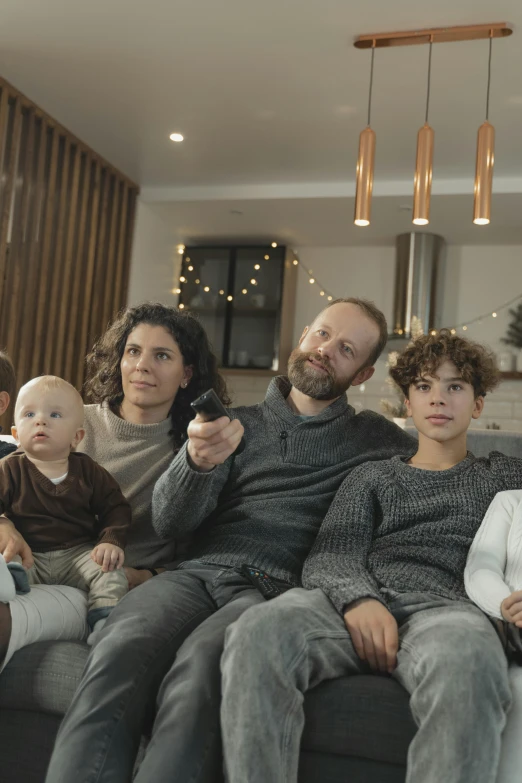 a group of people sitting on top of a couch, caring fatherly wide forehead, 4k tv still, promo image, holiday