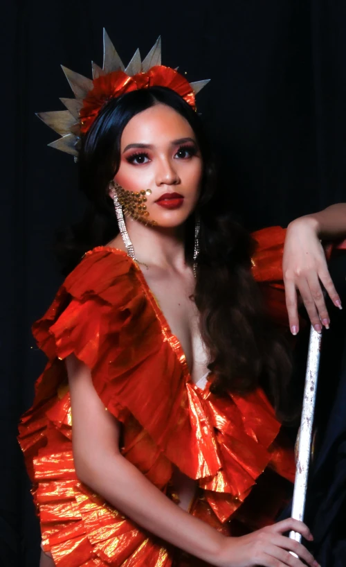 a woman in a red dress holding a flute, inspired by Ruth Jên, conceptual art, with a gold crown, press shot, vietnamese woman, doja cat