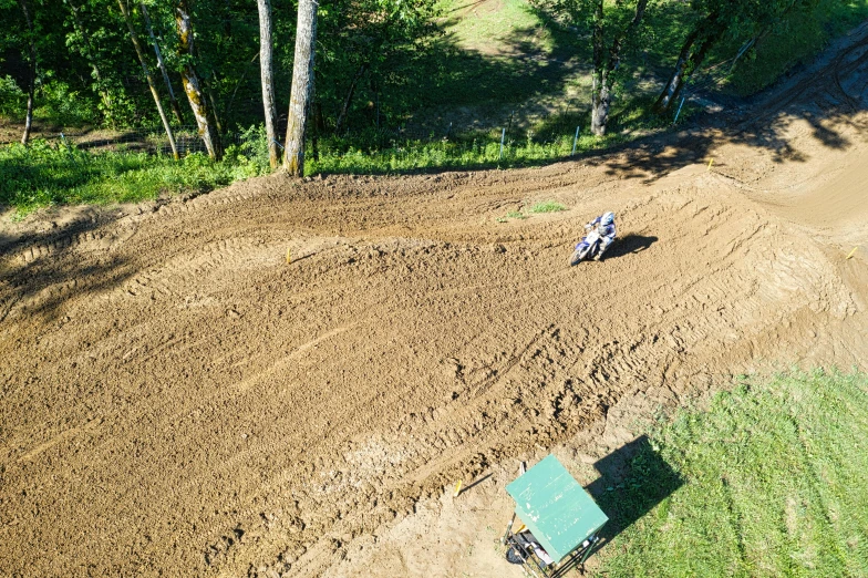 a person riding a dirt bike on a dirt track, viewed from bird's-eye, profile image, gardening, behind the scenes photo