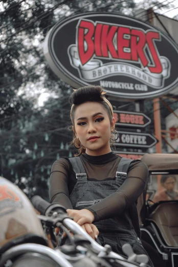 a woman sitting on the back of a motorcycle, an album cover, inspired by Rudy Siswanto, pexels contest winner, wearing rr diner uniform, black dress : : symmetrical face, bun ), asher duran