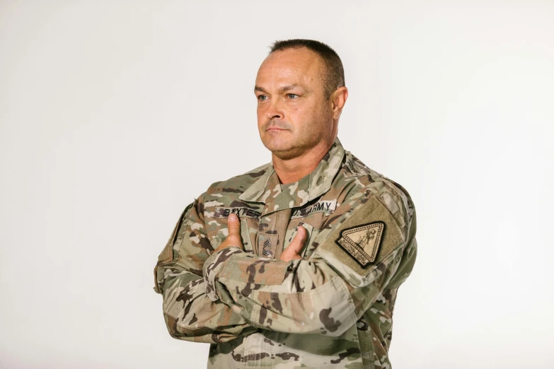 a man in a military uniform standing with his arms crossed, professional profile photo, greg rutkovski, multicam uniform, joe rogan