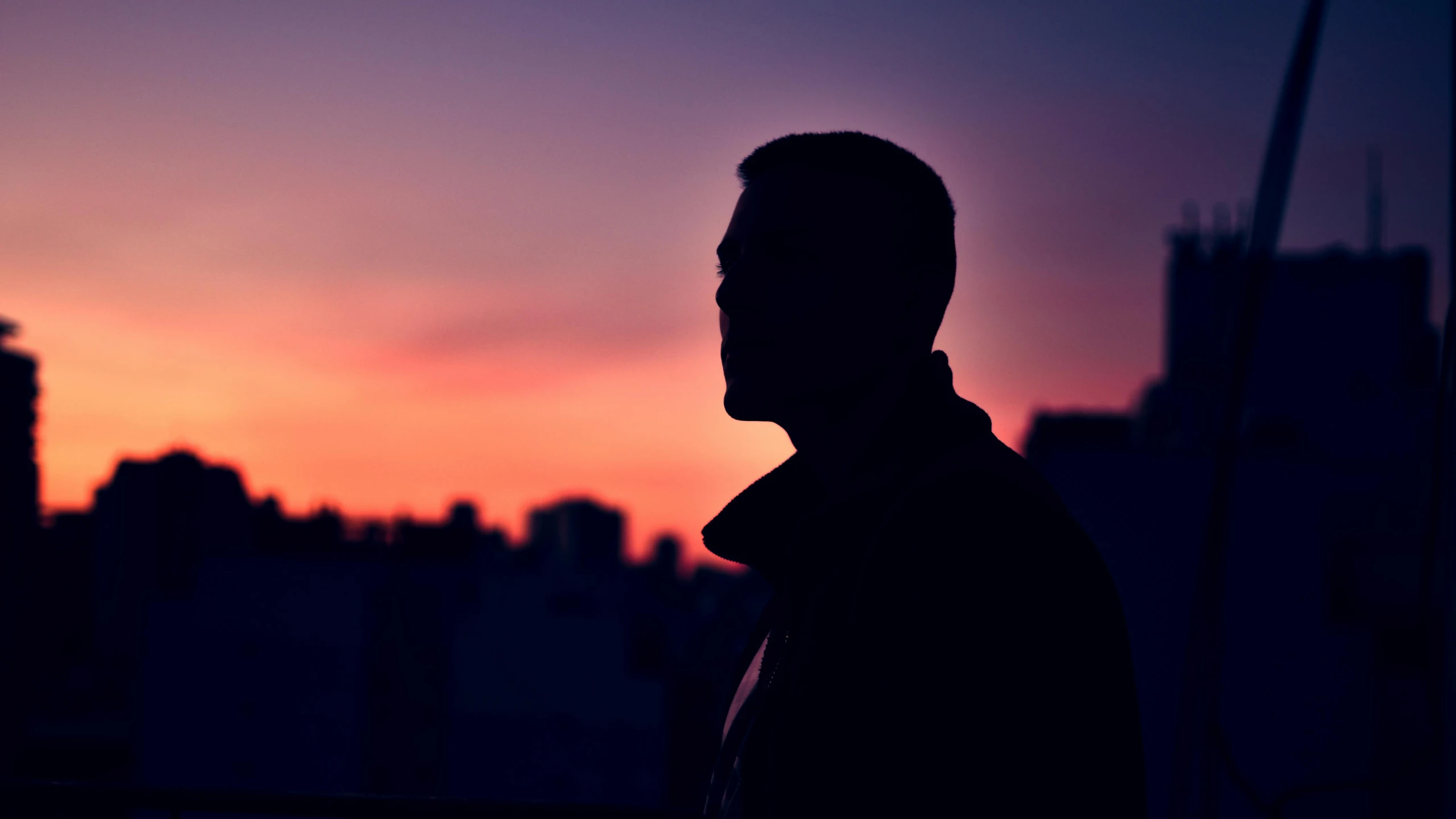 a silhouette of a man standing in front of a sunset, pexels contest winner, side profile cenetered portrait, city views, ad image, color photograph