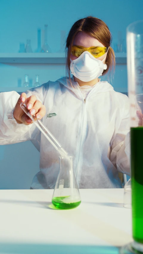 a woman in a lab coat pouring green liquid into a beaker, a picture, shutterstock, wearing a gas mask, low quality photo, fabric, student