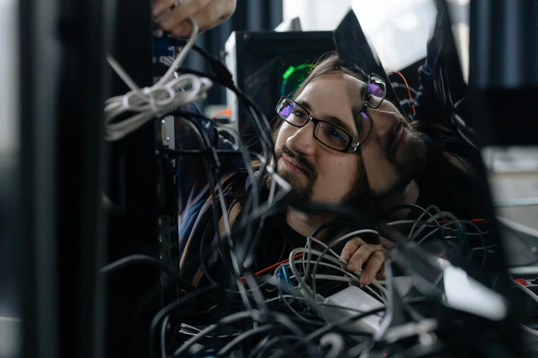 a man sitting in front of a bunch of wires, a portrait, reddit, gpus go brrr, repairing the other one, future coder looking on, close up portrait shot