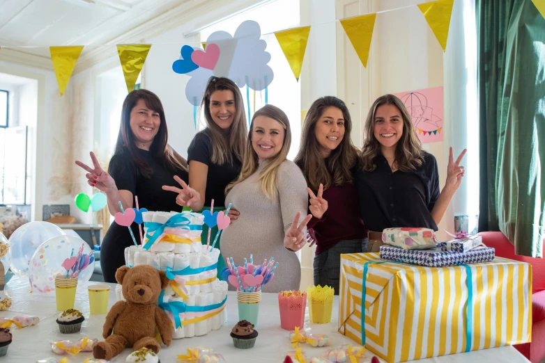 a group of women standing around a table with a cake, maternity feeling, avatar image, giorgia meloni, overflowing with diapers