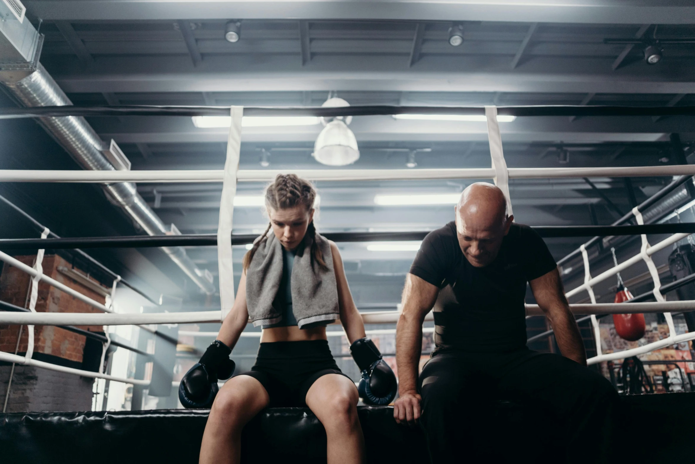 a man and a woman sitting in a boxing ring, pexels contest winner, local gym, lachlan bailey, disappointed, thrusters