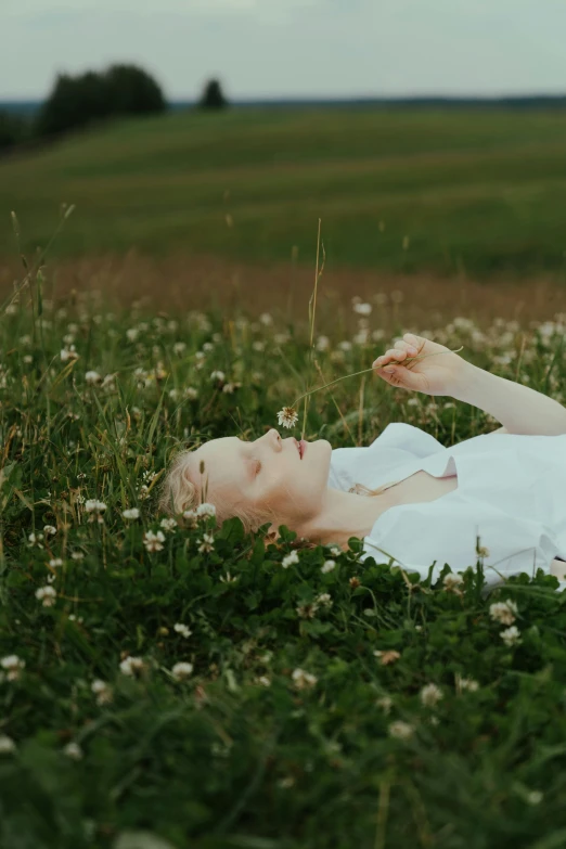 a woman laying on top of a lush green field, inspired by Elsa Bleda, pexels contest winner, romanticism, with a white complexion, ignant, humanoids overgrown with flowers, still frame from a movie