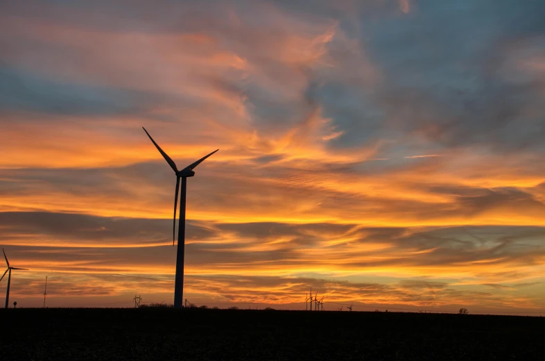 a group of wind turbines in a field at sunset, by Jesper Knudsen, pexels contest winner, fan favorite, sunset panorama, from wheaton illinois, under a technicolor sky