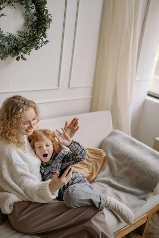 a woman sitting on top of a couch next to a child, pexels contest winner, waving, mobile game, soft and warm, smooth texture