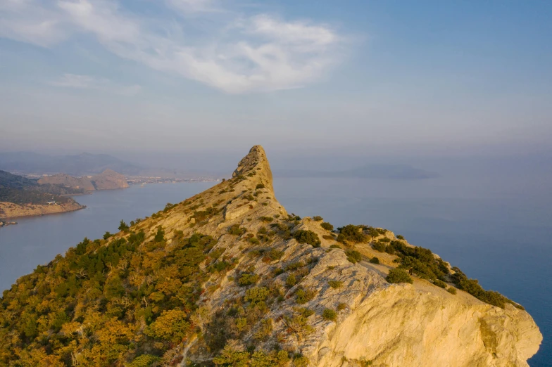 a large rock in the middle of a body of water, by Mathias Kollros, pexels contest winner, croatian coastline, on the top of a mountain, ehime, thumbnail