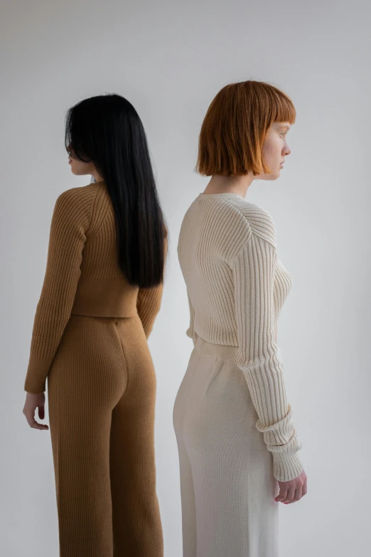 a couple of women standing next to each other, inspired by Vanessa Beecroft, renaissance, brown sweater, wearing tight suit, facing away from camera, browns and whites