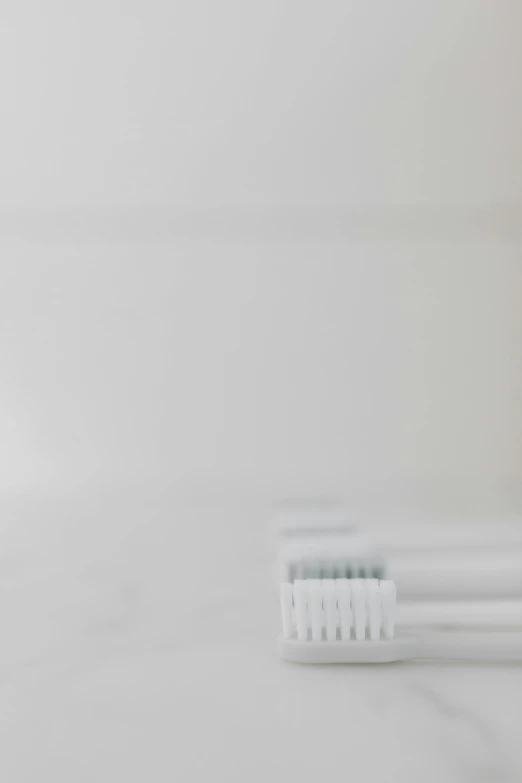 a couple of toothbrushes sitting on top of a counter, unsplash, minimalism, white architecture, everything is blurred, white fog, person