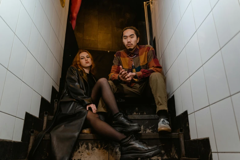 a man and a woman sitting on a set of stairs, pexels contest winner, international gothic, sydney sweeney, neon basement, zeen chin and terada katsuya, leather and suede