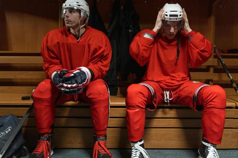 a couple of men sitting next to each other on a bench, by Jaakko Mattila, shutterstock, full ice hockey goalie gear, red sweatband, locker room, shot with sony alpha 1 camera