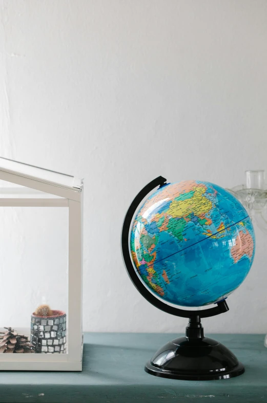 a small globe sitting on top of a table, at home, full colour, product shot, zoomed in