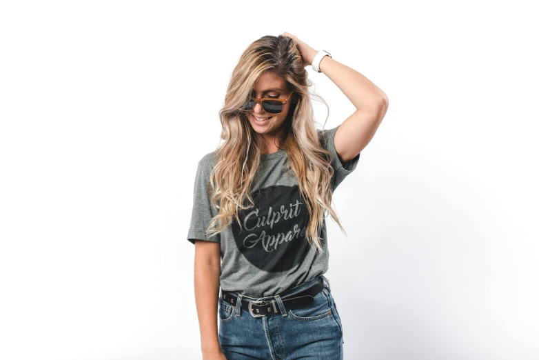 a woman wearing a grey shirt and jeans, by Everett Warner, unsplash contest winner, “modern calligraphy art, flipped out hair, themed after wine, outlive streetwear collection