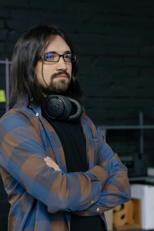 a man with headphones standing with his arms crossed, featured on reddit, wavy long black hair and glasses, felix englund, discord profile picture, promo image