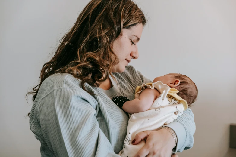 a woman holding a baby in her arms, pexels contest winner, charli bowater and artgeem, avatar image, high resolution, 1 2 9 7