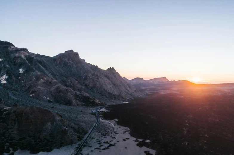 the sun is setting over a mountain range, by Lee Loughridge, unsplash contest winner, in socotra island, bird eye view, central california, leading lines