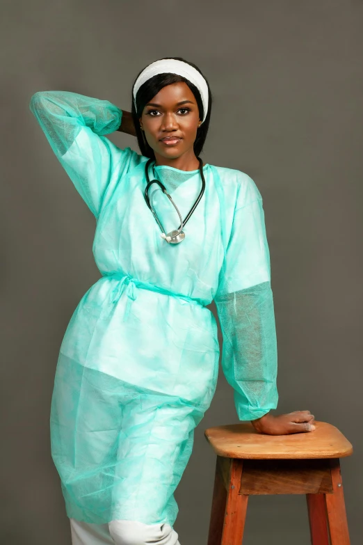 a woman sitting on a stool posing for a picture, an album cover, by Chinwe Chukwuogo-Roy, pexels, hurufiyya, surgical gown and scrubs on, translucent sss, turqouise, high quality upload