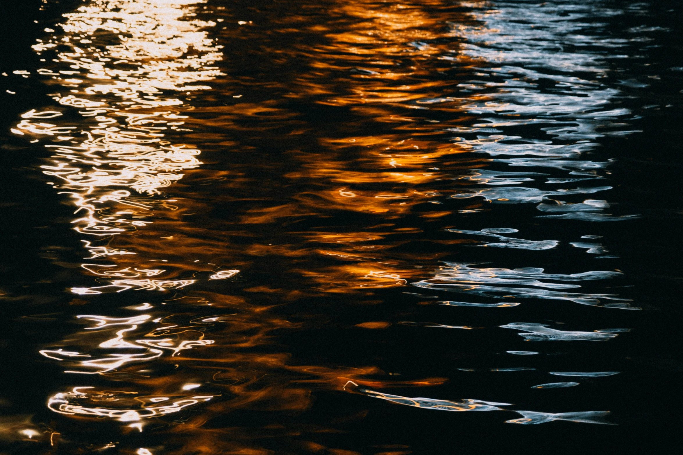 a body of water with lights reflecting off of it, inspired by Elsa Bleda, unsplash, lyrical abstraction, golden hour closeup photo, instagram post, waterways, orange glow