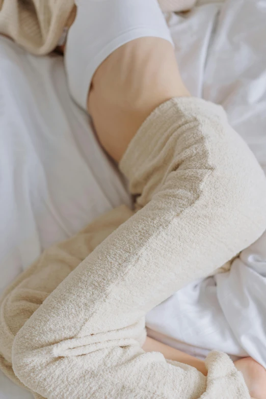 a close up of a person laying on a bed, inspired by Sarah Lucas, unsplash, wearing knee and elbow pads, cream, soft surface texture, white sleeves