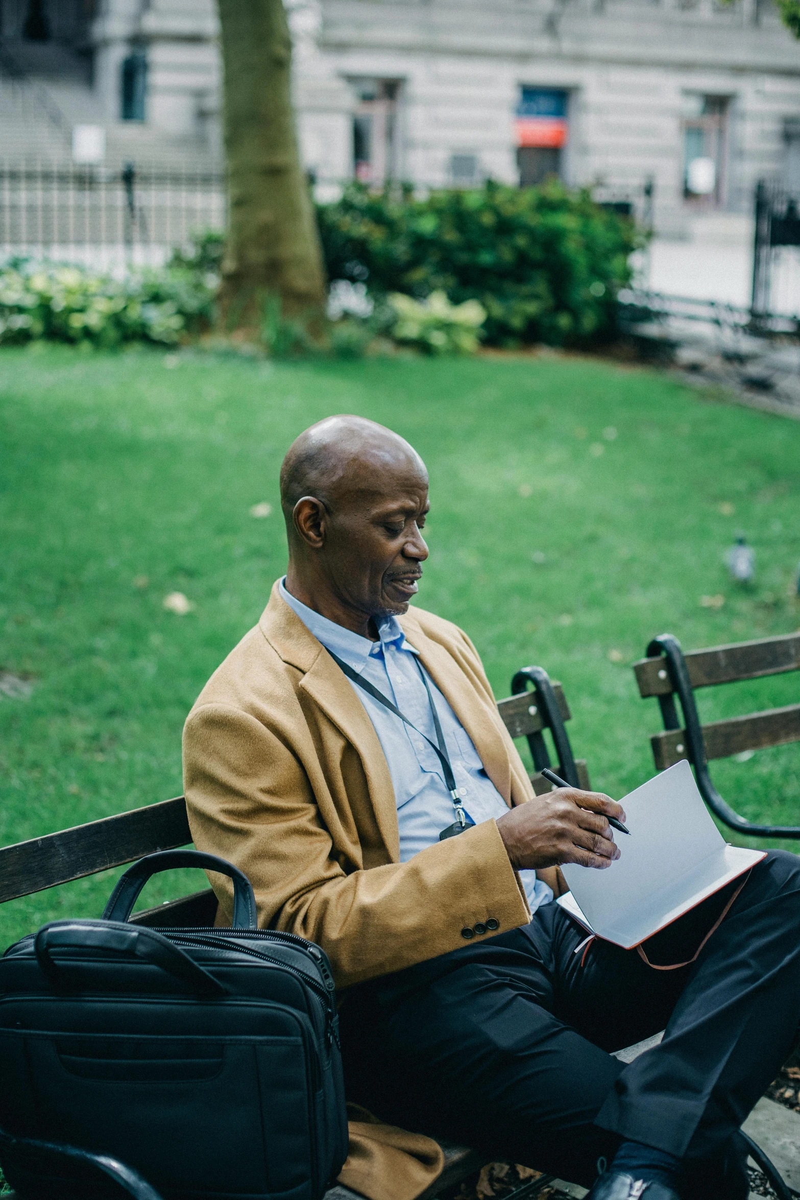 a man sitting on a bench reading a book, samuel l jackson, using a magical tablet, parks and public space, holding a briefcase