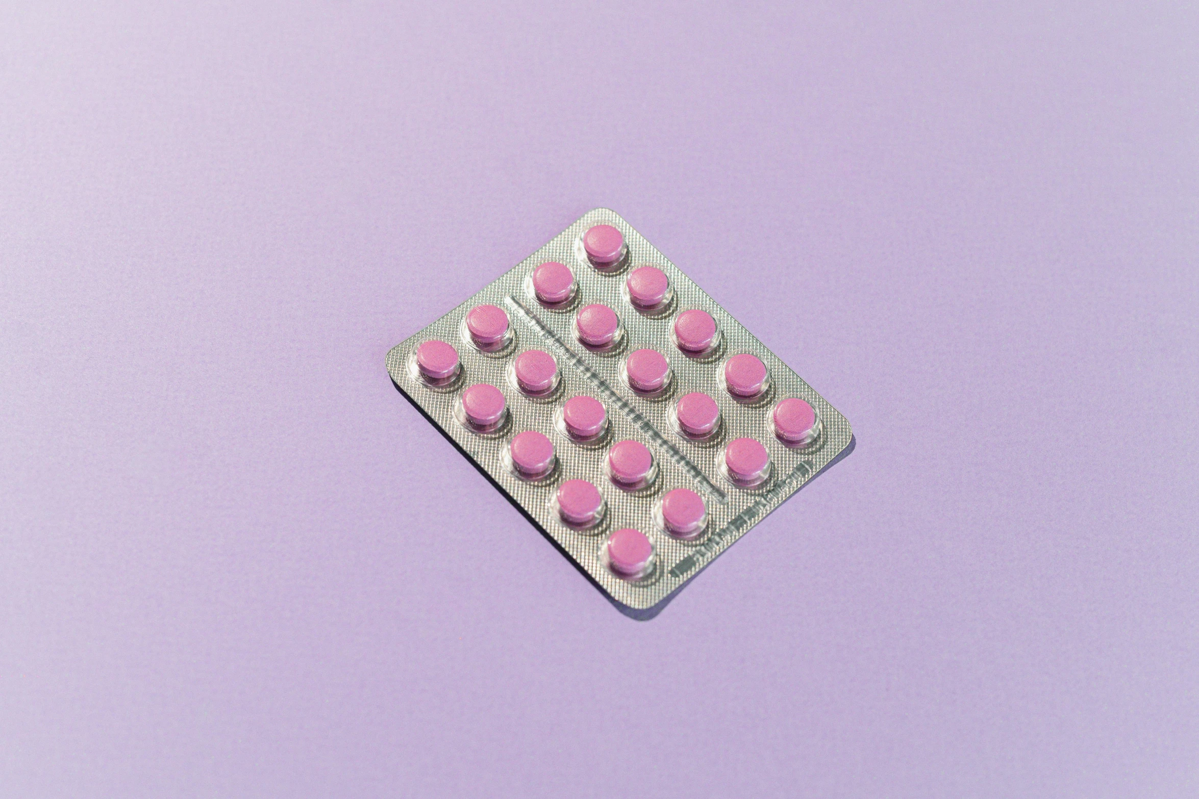 pink pills in a blister pack on a purple background, by Jan Kupecký, pexels, antipodeans, on grey background, hedi slimane, sitting down, ultrarealistic