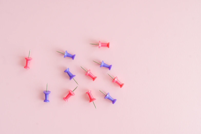 a bunch of push pins sitting on top of a pink surface, society 6, purples, healthcare, 1 2 9 7