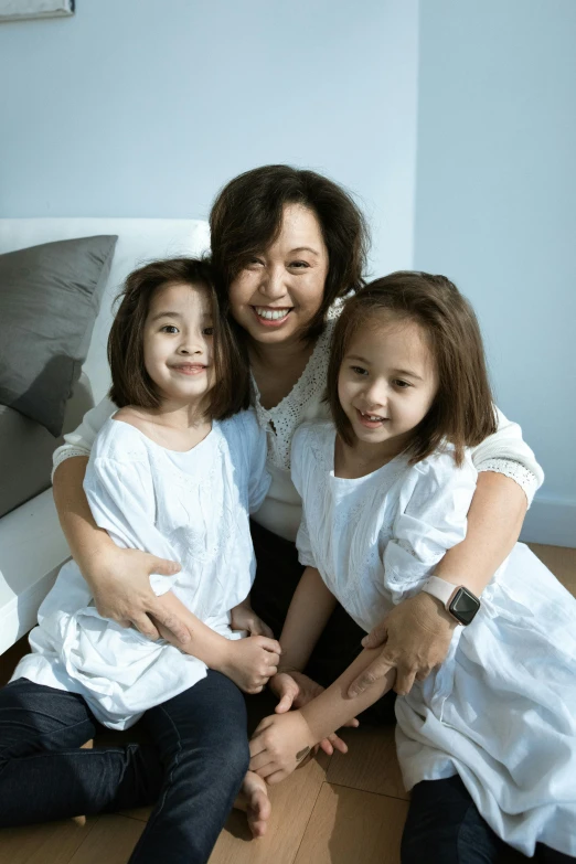 a woman and two young girls sitting on the floor, inspired by Cui Bai, incoherents, sitting on couch, wearing white clothes, joy ang, profile image