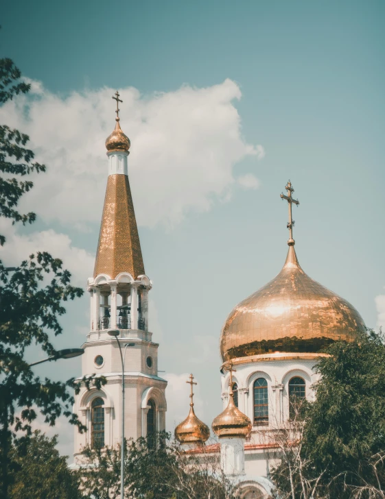 a group of people standing in front of a church, by Julia Pishtar, trending on unsplash, soviet architecture, gold and white, city buildings on top of trees, 000 — википедия