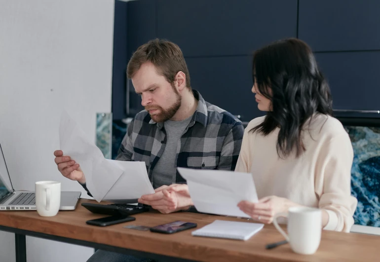 a man and a woman sitting at a table with papers, helpful, lachlan bailey, high budget, 15081959 21121991 01012000 4k