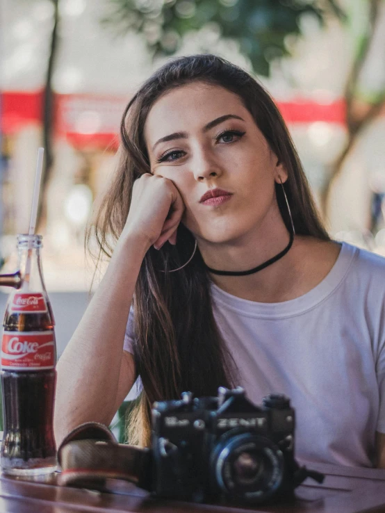 a woman sitting at a table with a camera, inspired by Elsa Bleda, trending on pexels, photorealism, soda themed girl, headshot profile picture, street pic, low quality photo