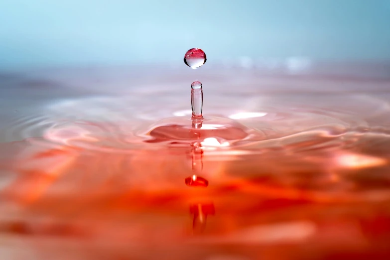 a drop of water falling into a body of water, a picture, by Jan Rustem, shutterstock contest winner, red hues, miniature product photo, 4 k hd wallpapear, high resolution print :1 red