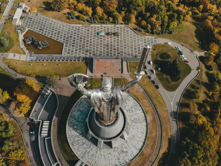 a large statue in the middle of a park, pexels contest winner, socialist realism, from a bird's eye view, massive structures, 🚿🗝📝