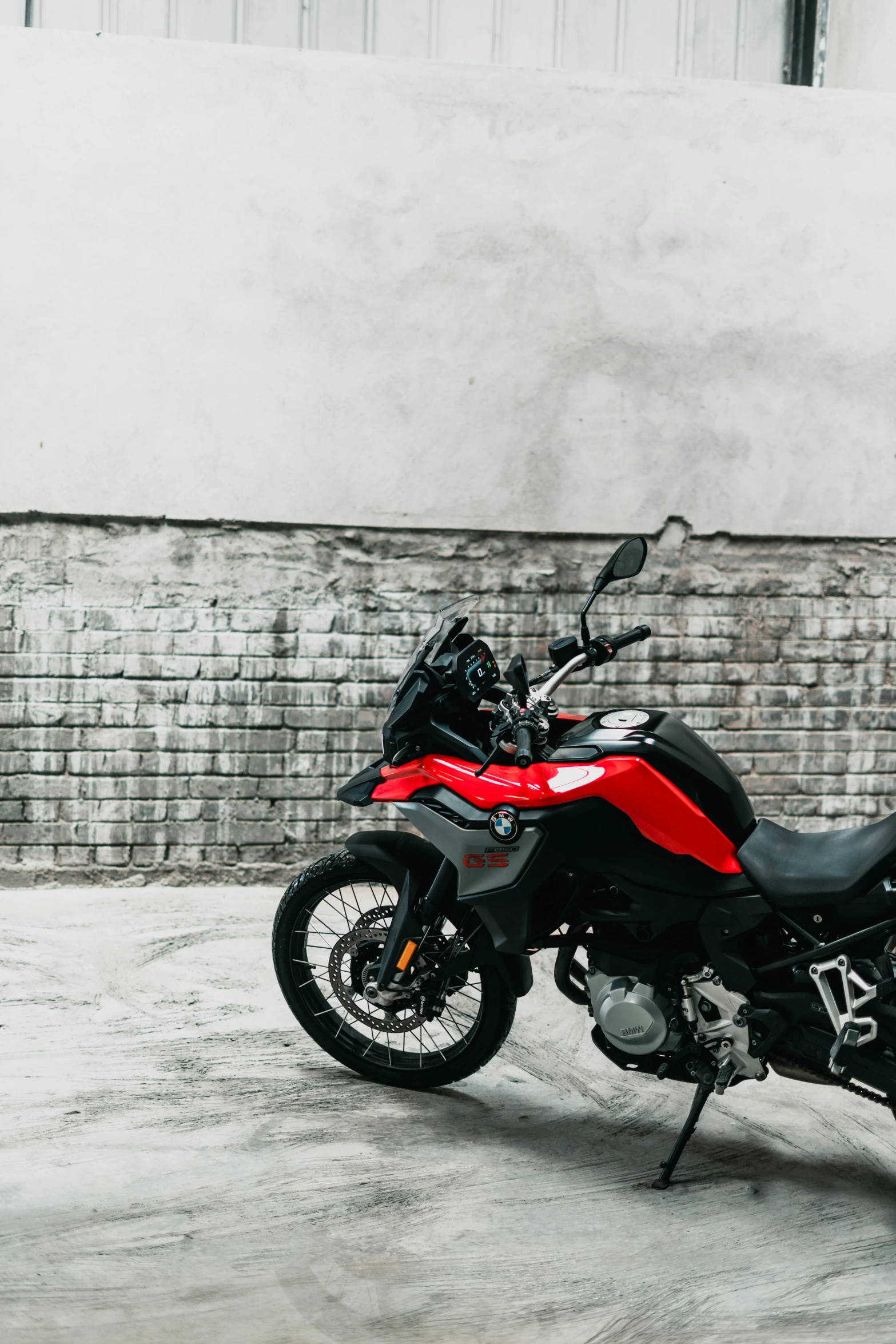 a red motorcycle parked in front of a building, profile image, off - road, grey, colour photograph