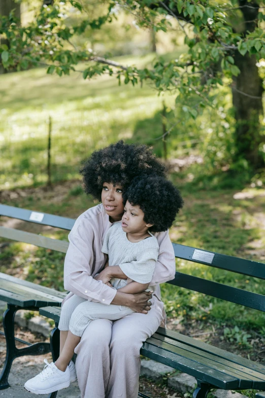 a woman and child sitting on a park bench, by Lily Delissa Joseph, pexels contest winner, long afro hair, central park, willow smith young, milk