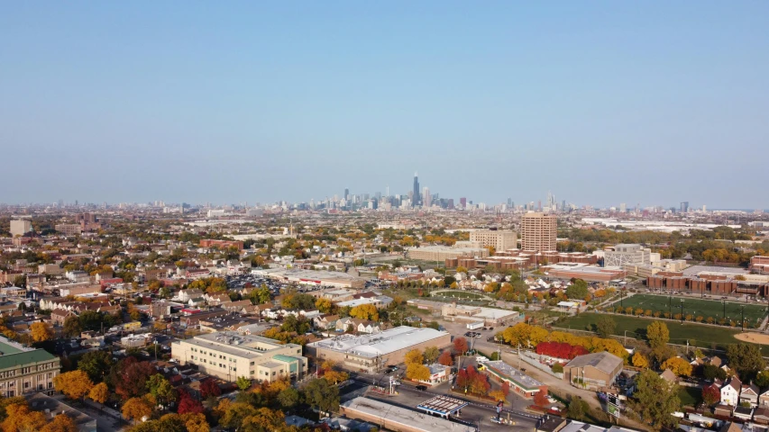 an aerial view of a city with a soccer field in the foreground, chicago skyline, clear skies in the distance, fall season, 15081959 21121991 01012000 4k