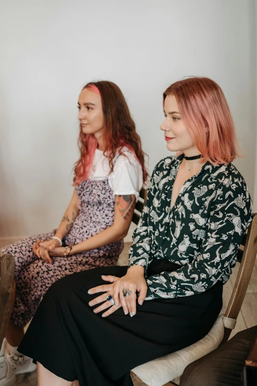 two women sitting in chairs talking to each other, a portrait, by Jessie Alexandra Dick, trending on pexels, pink straight hair, meditative, standing straight, low quality photo