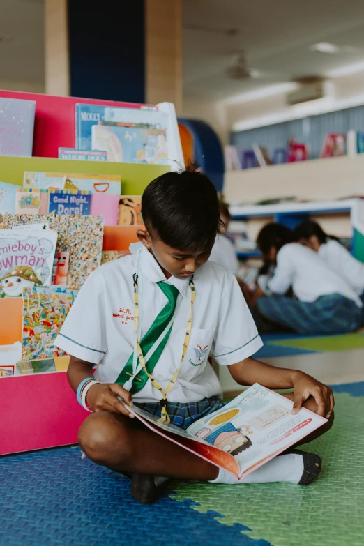 a boy sitting on the floor reading a book, a cartoon, pexels contest winner, danube school, sri lanka, in a library, girl wearing uniform, profile image