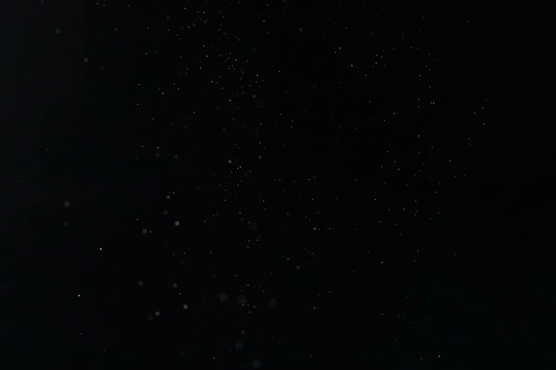 a man flying through the air while riding a snowboard, by Attila Meszlenyi, light and space, black sky full of stars, low quality footage, background image, solid black #000000 background