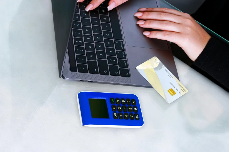 a person typing on a laptop next to a calculator, by Julia Pishtar, square, blue, digital photo, built on a small